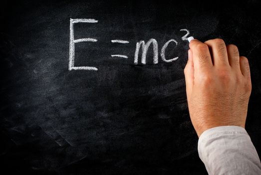 student writing on the chalkboard Einstein's formula e=mc2