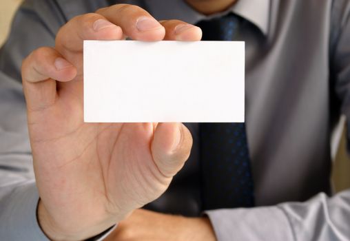 Businessman in office shows the business card in his hand