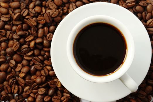 cup of coffee on a background of dark coffee beans