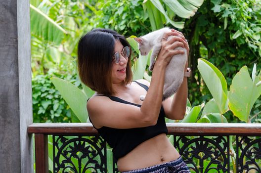 Beautiful Asian woman is playing with a cat