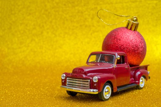 Toy car carries Christmas toy ball for holiday.