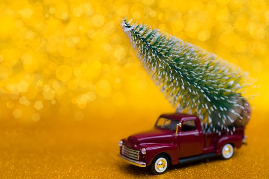 Toy car carries Christmas tree for holiday.