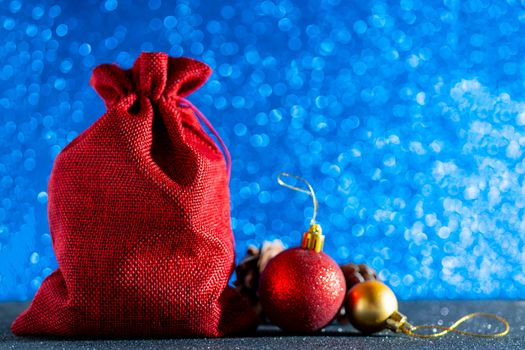Christmas blue background. Red gift bag and Christmas toys.