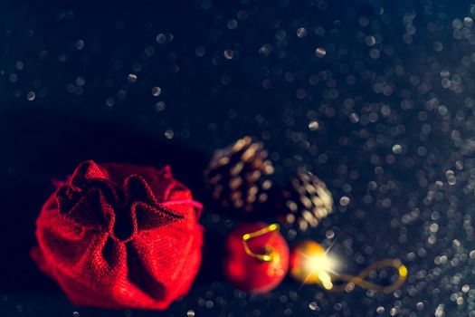 Christmas shiny black background. Red gift bag and Christmas toys.
