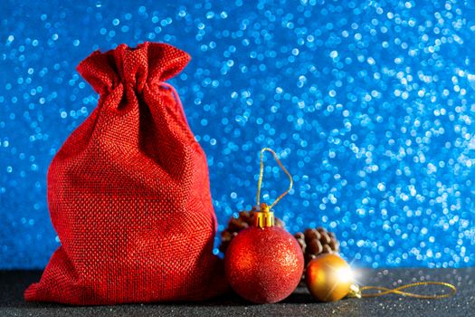 Christmas blue background. Red gift bag and Christmas toys.