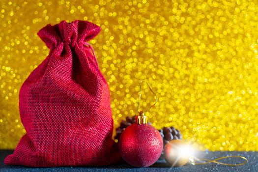 Christmas golden background. Red gift bag and Christmas toys.