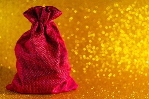 Christmas golden background. Red gift bag and Christmas toys.
