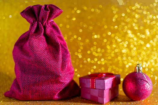 Christmas golden background. Red gift bag and Christmas toys.