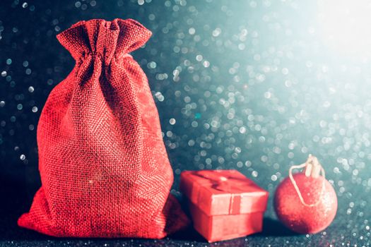 Christmas shiny black background. Red gift bag and Christmas toys.