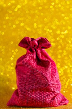 Christmas golden background. Red gift bag. Beautiful bokeh.