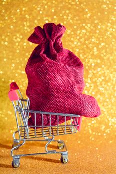 Christmas golden background. Christmas present in a supermarket trolley.