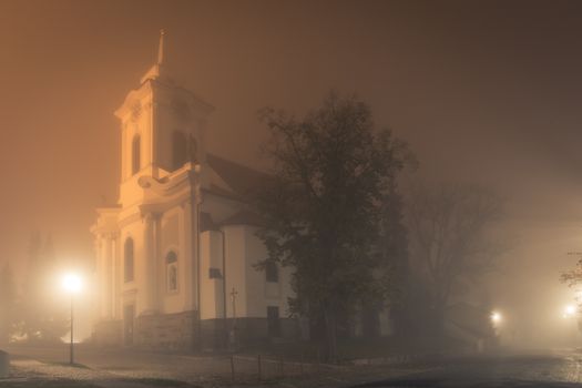 Old Church in fog at night, St. Gotgard Church in Cesky Brod, central bohemia region czech republic.