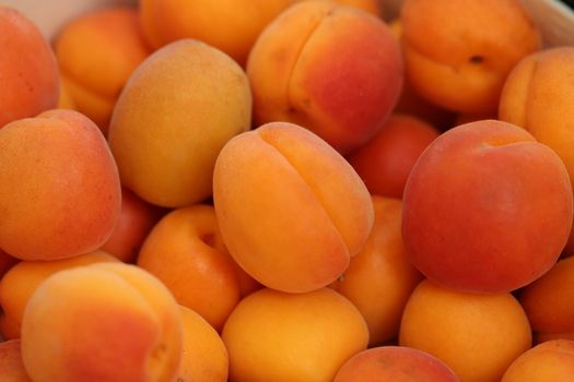 In images Background of bright beautiful juicy ripe orange apricots. The texture of the fruit halves, slices the workpiece to jam. The concept of the summer harvest, canning. Apricot day. Place for text.