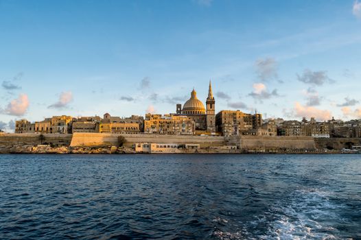 Panoramic view of Valletta Skyline at beautiful sunset from Sliema with churches of Our Lady of Mount Carmel and St. Paul's Anglican Pro-Cathedral, Valletta, Capital city of Malta