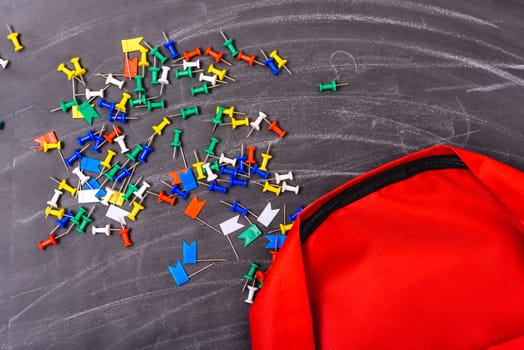 Back to school shopping backpack, on photo have red bag and colorful pin on blackboard and chalkboard