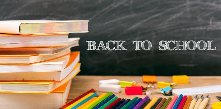 Classroom, with stack books on table have blackboard and chalkboard on background, back to school concept