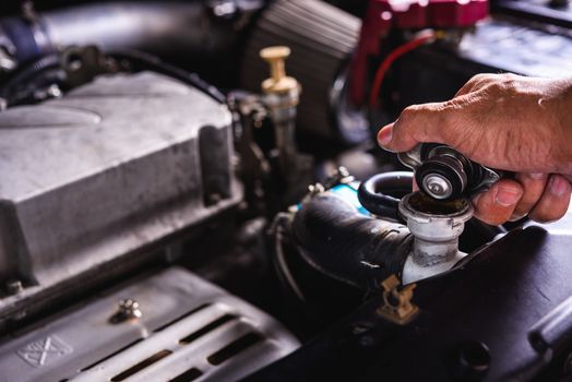 Hand of auto mechanic technician service check cooling water he open radiator cap the in garage