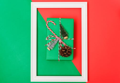 New Year, Christmas Xmas holiday composition, Top view gift green box, clews of rope, green fir tree branch on red and green background with copy space