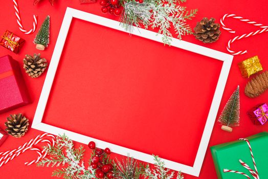 Christmas composition decorations, fir tree branches with Photo square frame on red background. Merry Christmas concept. Copy space for text