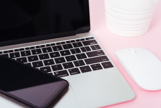 Top view of modern technology smart phone mobile and computer laptop on pink background with copy space