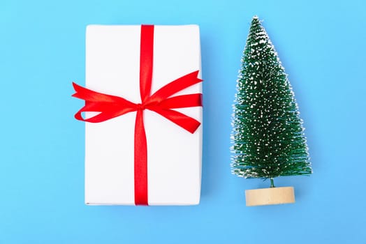 Happy New Year and Christmas 2020 or valentine day, top view craft paper wrapped present gift box craft and fir tree on blue background with copy space for your text
