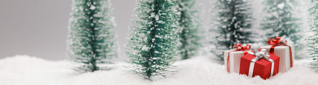 Christmas gifts in fir tree forest under snow