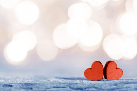 Two handmade wooden hearts on beautiful golden bokeh background. Vintage style. Love Valentine's Day concept.