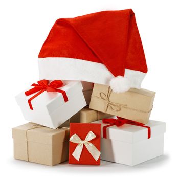 Christmas red and white gift boxes heap with Santa hat on top isolated on white background
