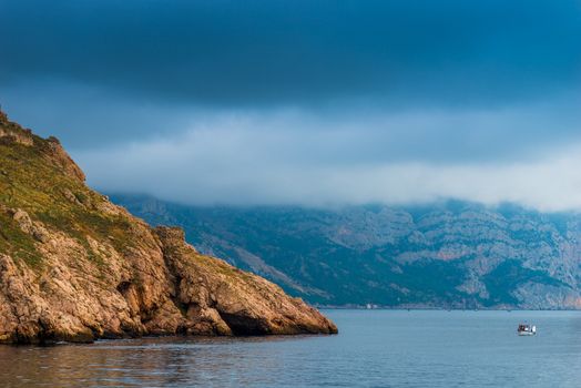 Nature seascape - rocky coast, calm sea and dramatic sky