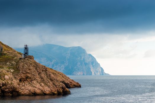 Beautiful scenery on a cloudy day - rocky coast, calm sea and dramatic sky