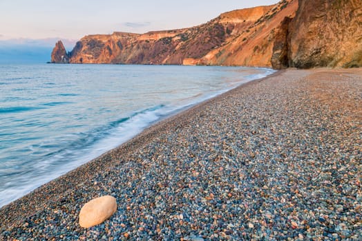 beach and view to Cape Fiolent, Crimea peninsula in the rays of the rising sun