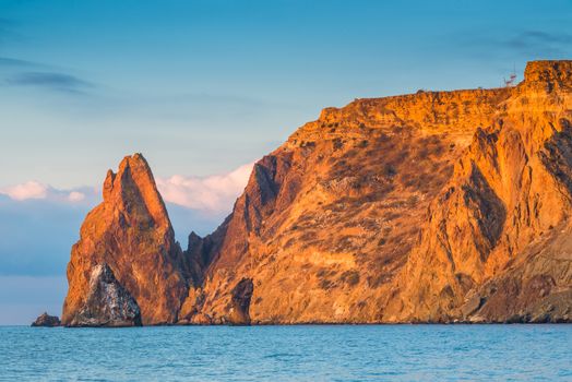 Cape Fiolent cliff against the backdrop of the sea in the sun at dawn in the morning, Russia, Crimea