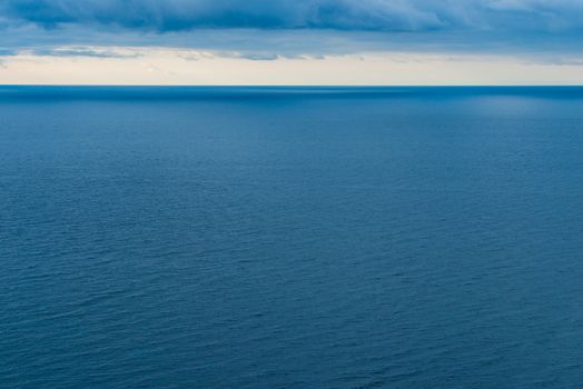 Blue sea water, view of the horizon and clouds, laconic seascape