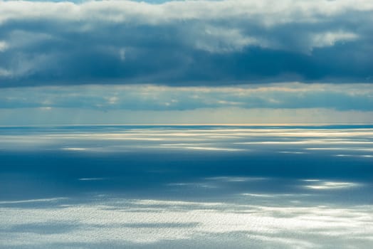 Sea surface in the rays of the sun breaking through the clouds