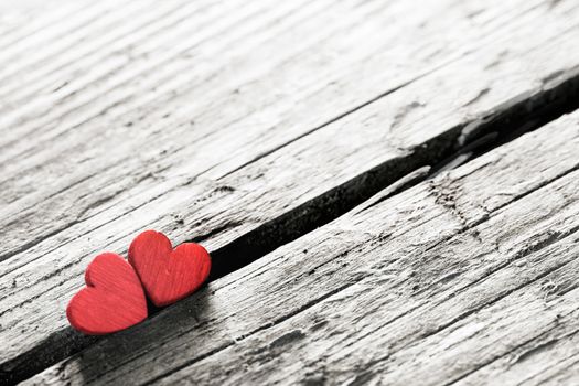 Two red handmade wooden carved hearts on wood background couple relationship Valentine day concept