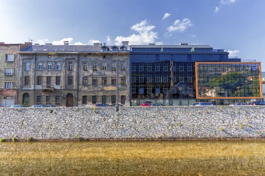 Old and modern buildings in Sarajevo by day and Milyacka River, Bosnia-Herzergovina