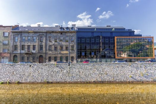 Old and modern buildings in Sarajevo by day and Milyacka River, Bosnia-Herzergovina