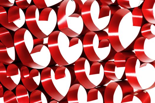 Red ribbons shaped as hearts on white background