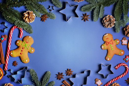 Christmas flat lay background with traditional gingerbread cookies dried orange cinnamon on blue , copy space for text