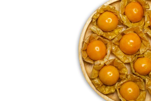 Cape gooseberry on wooden dish in white background. Concept of health care or herb. Top view and copy space for text.