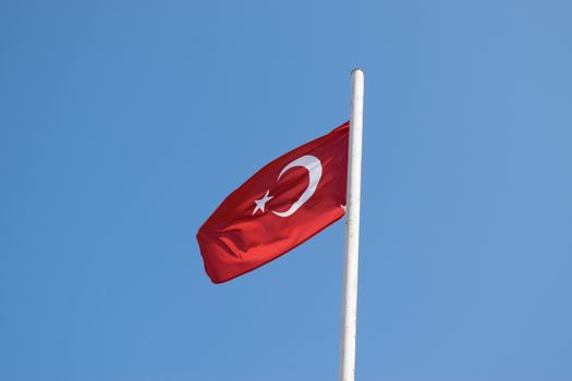 Turkish flag blowing against a blue skyscape