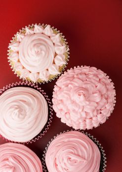 Top view of nice cupcakes with pink icing, red background