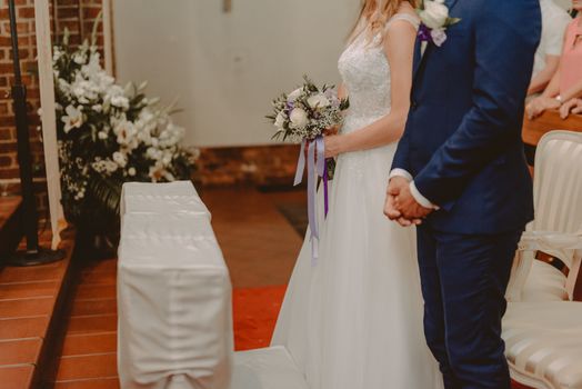 Bride and groom at church wedding during ceremony. Beautiful decoration