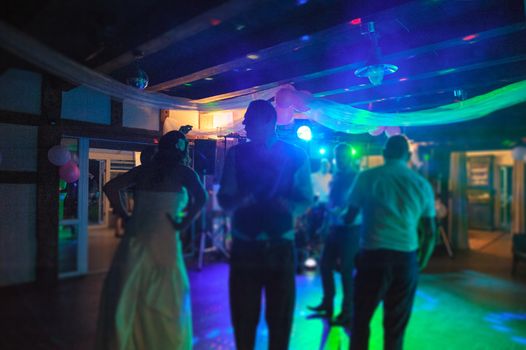 Bride and groom dancing the first dance at their wedding day. Guest on the dancefloor