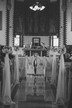 Church sanctuary before a wedding ceremony. Empty chairs for bride and groom