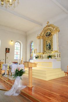 Church sanctuary before a wedding ceremony. Empty chairs for bride and groom