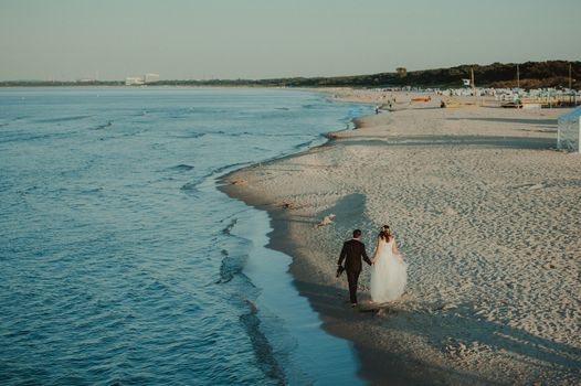 Bride and groom at a photo session in the nature. Baltic sea beach.