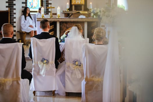 Bride and groom at church wedding during ceremony. Beautiful decoration
