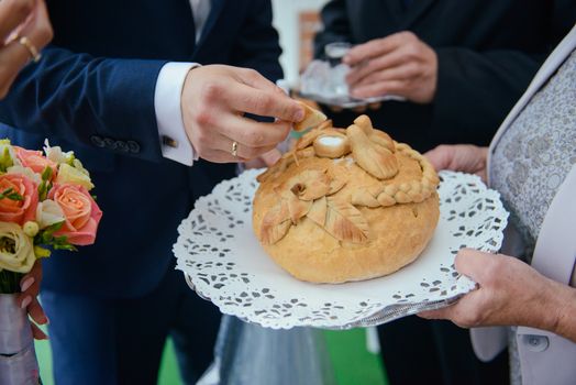 Traditional polish greeting the bride and groom by the parents with bread and salt. Vodka also in glasses.