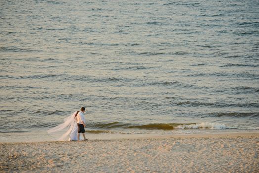 Bride and groom at a photo session in the nature. Baltic sea beach.